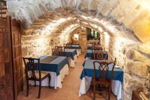 瓦德诺比斯拉卡萨德斯巴斯特昂酒店的餐厅拥有蓝色的桌椅,位于石墙内
