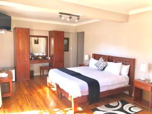 约翰内斯堡Lido Hotel的卧室配有白色大床和木制家具
