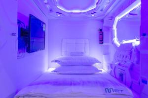 新加坡MET A Space Pod at Arab Street的紫色灯房内的小床