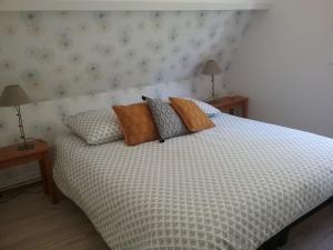 SeigyAu Nid Douillet的一间卧室配有一张带枕头的床和两盏灯。