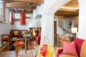 布勒伊-切尔维尼亚圣胡贝图斯度假酒店的客厅配有红色家具和壁炉