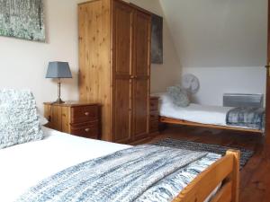 RuffiacLe Grenier, La Vieille Ferme的一间卧室设有两张床和木制橱柜