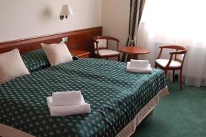 海布考莫尼壶卡酒店的酒店客房,配有带两条毛巾的床