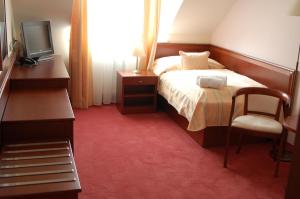 海布考莫尼壶卡酒店的一间卧室配有一张床、一台电视和一把椅子