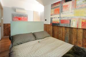奥林达科莫别墅住宿的卧室配有一张床,墙上挂有绘画作品