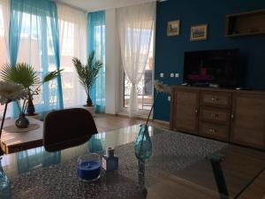 切尔诺莫雷茨Azur Apartment Deluxe的客厅配有电视和桌子上的花瓶