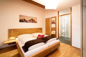 东蒂罗尔地区马特赖阿尔卑斯玛特雷公寓的一间卧室配有一张大床和木制床头板