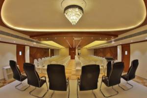 根尼亚古马里Annai Resorts & Spa的一间会议室,配有白色椅子和吊灯