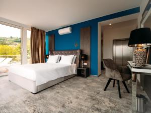 波尔托罗Boutique Hotel Portorose的卧室配有一张白色大床和一张书桌