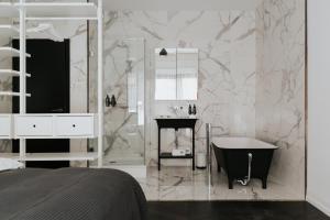 布达佩斯TG Hotel Apartments Budapest的白色的浴室设有浴缸和水槽。