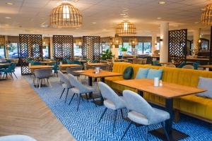 德科赫波斯查德酒店的餐厅设有桌椅和沙发。