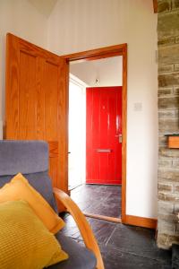 阿基尔Butterfly Cottage的一间带红色门和沙发的客厅