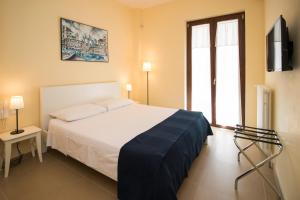 孔韦尔萨诺Corte dei Nobili的卧室配有一张白色大床和电视。