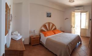 雷妮Albergo Seaside的一间卧室配有一张带橙色枕头的大床