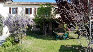 阿斯蒂San Rocco di Villa di Isola D'Asti的院子里紫色紫藤的房子