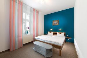 宾茨Haus Zobler的一间卧室设有一张床和蓝色的墙壁
