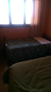 圣安东尼奥Hostal Panorámico的一间卧室配有一张床和一个阳光窗户