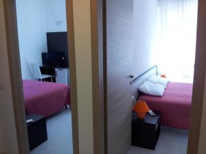 萨杜勒尼亚得力士圣安尼酒店的一间卧室设有两张床和一个带书桌的窗户。