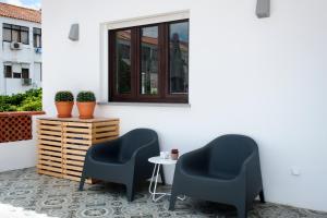 蒙蒂茹Apartamento modeno e acolhedor com terraço的庭院里设有两把椅子和一张桌子