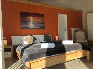 宾茨豪斯伊斯基亚公寓的一间卧室配有一张带橙色墙壁的大床