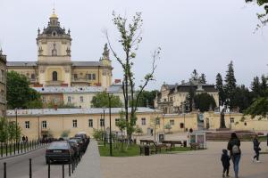 利沃夫Old Lviv Apartment的一座大型建筑,前面有汽车停放