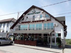 Pădurea UrziceniWestmotelrestaurant的一座有标志的建筑,上面有西边的汽车旅馆