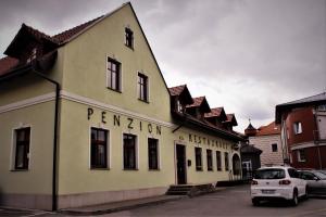 萨扎瓦河畔莱代奇Penzion a restaurace U ŘEKY的停在大楼前的白色汽车