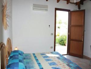 普雷西切Residence Il Giunco的一间卧室配有一张带蓝色和白色被子的床