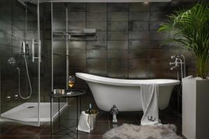 梅杜林Boutique Hotel Chevalier - Adults Only的设有带浴缸和淋浴的浴室。
