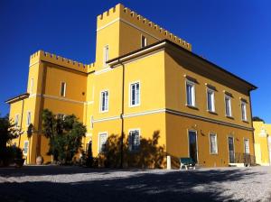 瓦达Villa Graziani的一座黄色的建筑,上面有一座塔