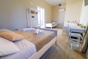 特拉帕尼Stabile Hospitality的一张大床,位于带书桌的房间和一间卧室