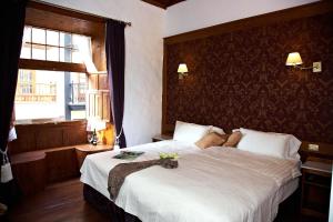 伊科德洛斯维诺斯埃姆布勒玛提卡圣奥古斯丁酒店的一间卧室设有一张大床和一个窗户。