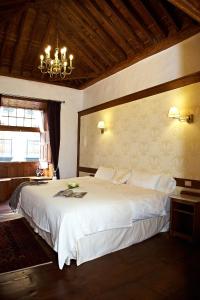 伊科德洛斯维诺斯埃姆布勒玛提卡圣奥古斯丁酒店的卧室配有一张白色大床和吊灯。