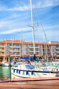 阿尔梅利马Expoholidays - Apartamentos Puerto Almerimar的停靠在建筑物旁边的码头的帆船