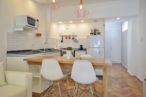 布宜诺斯艾利斯Apartamento en el mejor sitio de Recoleta的厨房配有木桌和白色椅子