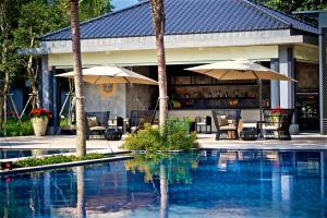 吉安秧悦美地度假酒店的毗邻度假酒店的带椅子和遮阳伞的游泳池