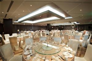 吉安秧悦美地度假酒店的一个带白色桌子和白色椅子的大型宴会厅