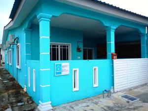 瓜拉雪兰戈AZURE SKY HOMESTAY KUALA SELANGOR的蓝色的房子,有白色的门和柱子
