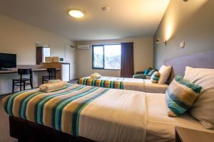 金斯顿Kingston hotel Motel的酒店客房带两张床和厨房