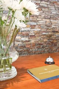 圣伊西德罗圣伊西德罗广场酒店的书旁边的桌子上装有白色花的花瓶