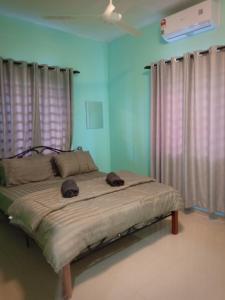 瓜拉雪兰戈AZURE SKY HOMESTAY KUALA SELANGOR的一间卧室,配有一张带两顶帽子的床