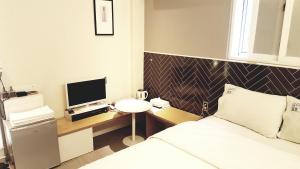 大邱翁多汽车旅馆的一间卧室配有一张床和一张书桌及电视