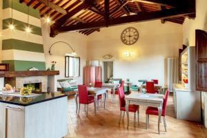 皮恩扎Il Mastio di Spedaletto的厨房以及带桌子和红色椅子的用餐室。