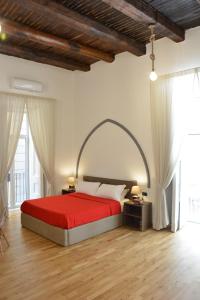 那不勒斯Domus Studio 25 bed & breakfast的一间设有红色床的卧室,位于带窗户的房间内