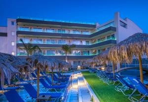 赫索尼索斯无限蓝精品酒店及Spa - 仅限成人的一个带椅子和遮阳伞的酒店和一个游泳池