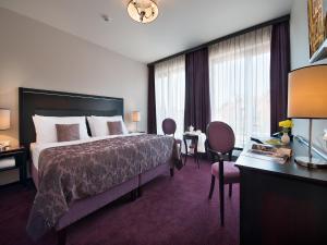 布拉格布拉格EA大使酒店的酒店客房带一张床、一张桌子和椅子