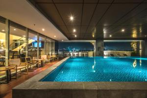 泗水Oakwood Hotel & Residence Surabaya的一座配有桌椅的酒店游泳池