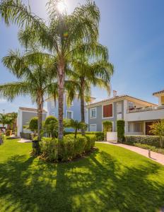 EsteponaCortijo Del Mar Resort的庭院里种有棕榈树的大房子
