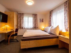 阿特尔高地区圣格奥尔根Siri's Einkehr的一间卧室配有一张带书桌的床和窗户。