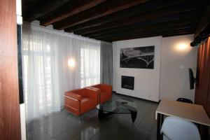列日Amosa Liège City Centre Apart Regence 10的客厅配有橙色沙发和玻璃桌
